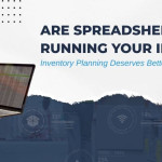 Warehouse inventory worker uses laptop for stock